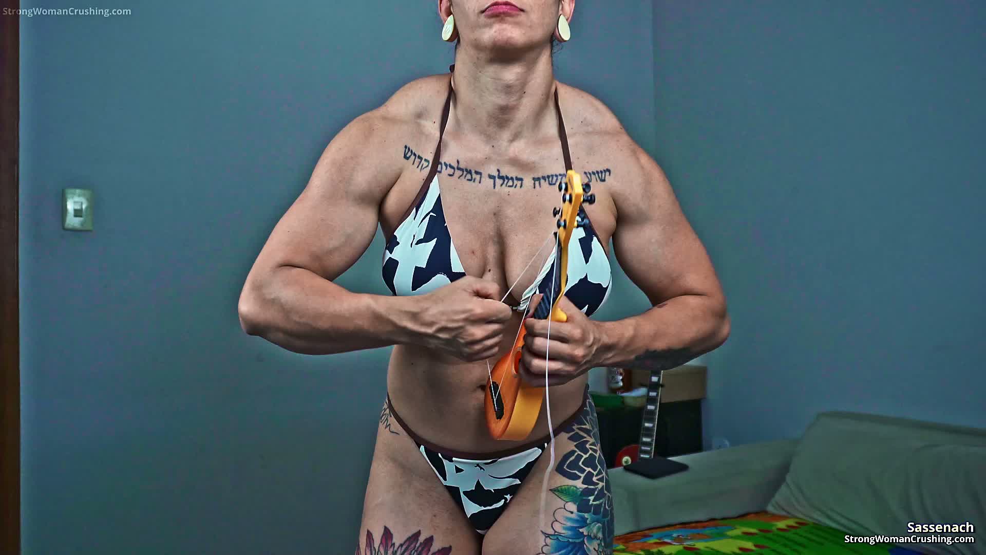 Sassenach destroys a mini-guitar with her muscles.